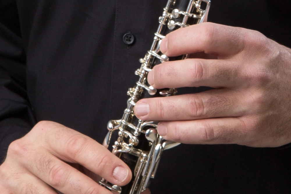 Zwei Hände, welche eine Oboe spielen
